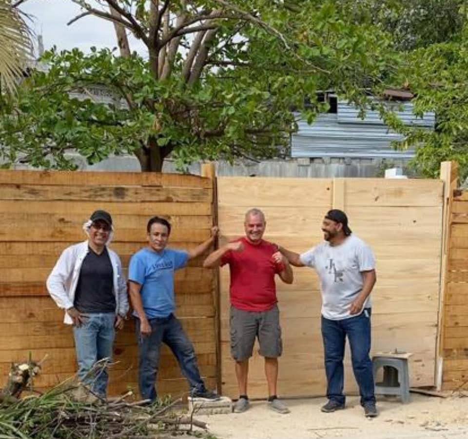 Men fence men in front of a wooden fence